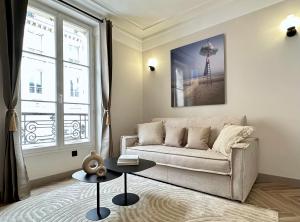 a living room with a couch and a table at Charming Apartment with Eiffel Tower View in Paris