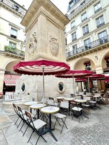 a group of tables and chairs in front of a building at Charming Apartment with Eiffel Tower View in Paris