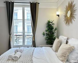 a bedroom with a white bed with towels on it at Charming Apartment with Eiffel Tower View in Paris