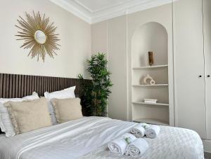 a bedroom with a bed with five rolled towels at Charming Apartment with Eiffel Tower View in Paris