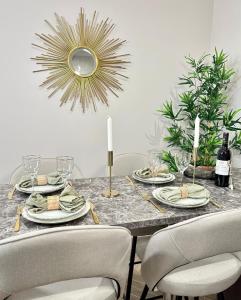 a dining room table with chairs and a gold mirror at Charming Apartment with Eiffel Tower View in Paris