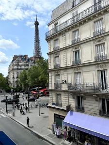 a street with a building and the eiffel tower at Charming Apartment with Eiffel Tower View in Paris