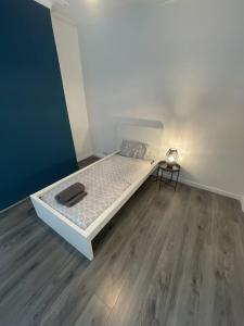 a small bedroom with a bed and a wooden floor at Boutique Accommodation in Central Location in Liverpool