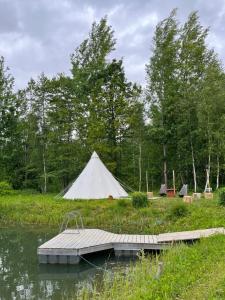 uma tenda branca e uma doca no meio de um lago em Tipi telk Jantsu talus 
