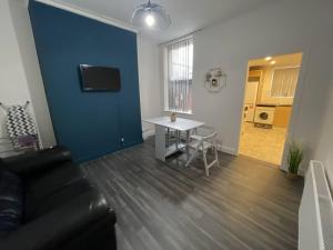 a living room with a couch and a table and a blue wall at Boutique Accommodation in Central Location in Liverpool