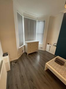 an empty room with a bed and a desk at Boutique Accommodation in Central Location in Liverpool