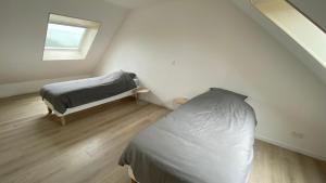 a white bedroom with a bed and a window at L’apparté, meublé de tourisme in Saint-Folquin +12 photos