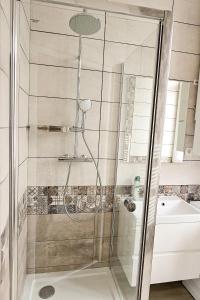 y baño con ducha y puerta de cristal. en Les Appartements de la Nef d'Or en Saint-Quentin