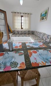 a dining room table with chairs and a couch at Recanto Do Sol Bertioga in Bertioga