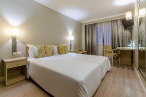 a bedroom with a large white bed in a room at Olissippo Marquês de Sá in Lisbon