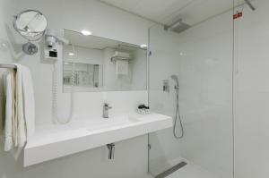 Un baño blanco con lavabo y ducha. en Olissippo Marquês de Sá, en Lisboa