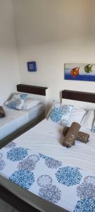 dwa łóżka siedzące obok siebie w pokoju w obiekcie Recanto Do Sol Bertioga w mieście Bertioga
