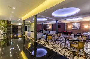 リスボンにあるオリシッポ マルケス デ サのホテルのロビーには、テーブルと椅子のあるレストランがあります。