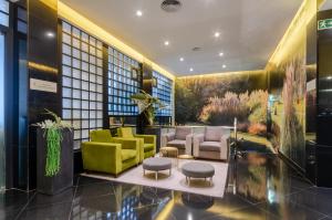 a lobby with yellow and green furniture in a building at Olissippo Marques de Sa in Lisbon