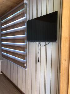 uma televisão de ecrã plano pendurada numa parede com uma janela em Riverside Tekhuri em Martvili