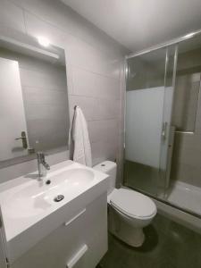 a bathroom with a toilet and a sink and a shower at San Centro Wizink IFEMA Metropolitano Airport Apartments in Madrid