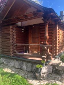 a log cabin with a porch on the side of it at Sofra Kolonjare Agroturizem in Ersekë