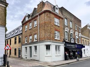 a large brick building on the corner of a street at The Ravenscourt Park Escape - Bright 2BDR Flat in London
