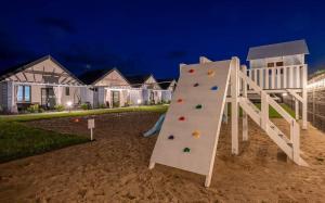 a playground with a slide in front of a house at Niebiańska Przystań Rusinowo in Rusinowo