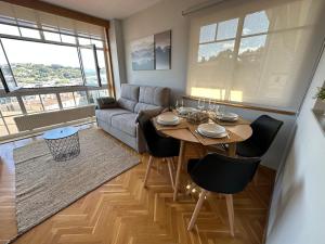ein Wohnzimmer mit einem Tisch und einem Sofa in der Unterkunft Oktheway Los Arces in A Coruña