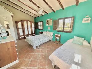 zwei Betten in einem Zimmer mit grünen Wänden in der Unterkunft Cortijo Cuscurro in Ríogordo + 22 Fotos