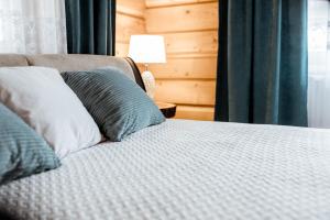 Una cama con almohadas azules y blancas en un dormitorio en Pokoje Gościnne Monika III en Zakopane