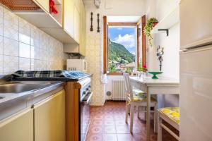 a kitchen with a sink and a table with a window at Casa nel Borgo Rose in Breguzzo