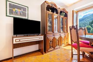 a living room with a large entertainment center and a flat screen tv at Casa nel Borgo Rose in Breguzzo