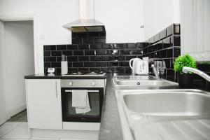 a kitchen with a sink and a stove at Serene and Tranquil Escape in Liverpool