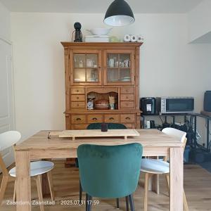 una mesa de comedor con sillas y una cabaña de madera en Double room in private home, en Zaandam