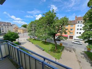 einen Balkon mit Blick auf eine Straße und einen Baum in der Unterkunft East Park Apartments Baumkirchner Str 18 in München