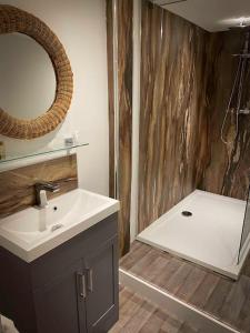 a bathroom with a sink and a mirror and a tub at The Nash Suite - one minute walk to beach in Brighton & Hove