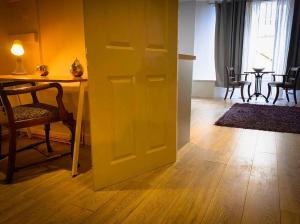 a yellow door in a room with a table and chairs at The Nash Suite - one minute walk to beach in Brighton & Hove