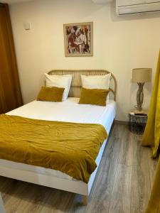 a bedroom with a large bed with yellow sheets at Charmant appartement à Ajaccio in Ajaccio