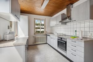 a kitchen with white appliances and a wooden ceiling at home2stay worker Apartments Nürtingen-Zizishausen Ap1 in Nürtingen