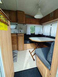 Ein Wohnmobil mit einem Tisch und einer Küche in der Unterkunft Peipsi Tiheda Чудское озеро in Tiheda