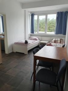 Habitación con mesa, cama, mesa y sillas. en Akdeniz Pension en Ludwigsfelde