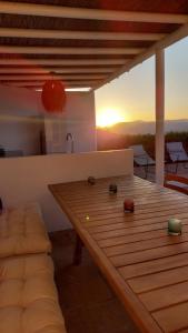 - une table en bois dans le salon avec vue sur le coucher du soleil dans l'établissement El Paraíso Perdido, à Casabermeja