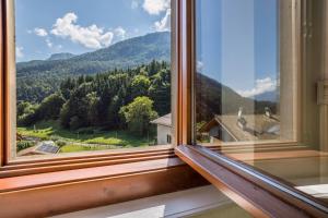una finestra con vista sulle montagne di Casa nel Borgo Edera a Breguzzo