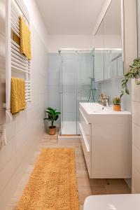 a bathroom with a white sink and a shower at Waterfront Luxury Residence - Paid Parking Option in Budapest +13 photos