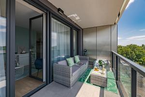 a balcony with a couch and a table at Waterfront Luxury Residence - Paid Parking Option in Budapest