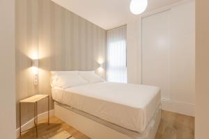 - une chambre blanche avec un lit et une fenêtre dans l'établissement Jardines del Valle Jacuzzi 5 pax, à Séville