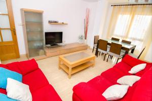 a living room with a red couch and a table at Apartamento de 4 dormitorios muy céntrico en San Juan Pueblo a tan sólo 2,5 km de la playa de San Juan y Muchavista in San Juan de Alicante