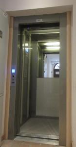 a glass elevator door in a building with a mirror at Torretta International in Trieste