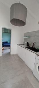 een keuken met een wastafel en een bed in een kamer bij Un cocon les pieds dans l'eau in Le Moule