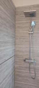 a shower with a shower head in a bathroom at Un cocon les pieds dans l'eau in Le Moule