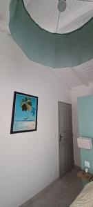 a room with a ceiling with a picture on the wall at Un cocon les pieds dans l'eau in Le Moule