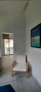 a white couch in a room with a poster on the wall at Un cocon les pieds dans l'eau in Le Moule