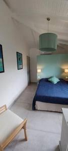 a bedroom with a blue bed and a green ceiling at Un cocon les pieds dans l'eau in Le Moule