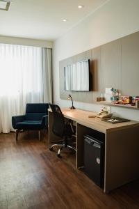 an office with a desk and a chair and a monitor at Blue Tree Premium Faria Lima in São Paulo